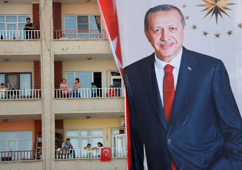 FILE PHOTO: People watch an election rally of Turkish President Tayyip Erdogan from a building in Mardin