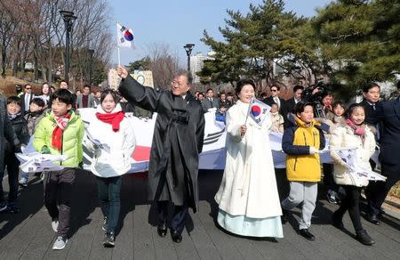 South Korean President Moon Jae-in and his wife Kim Jung-Sook march with participants during a ceremony celebrating the 99th anniversary of the March First Independence Movement against Japanese colonial rule in Seoul, South Korea, March 1, 2018. Yonhap via REUTERS