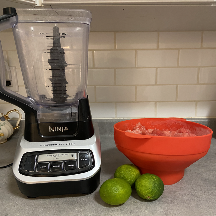 A blender, the bowl of watermelon chunks, and three limes sitting on my countertop