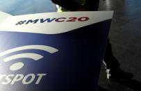 An employee walks past an MWC20 banner in Barcelona