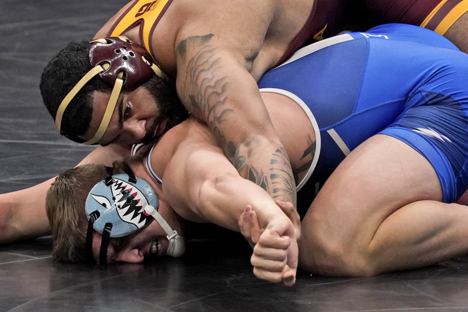 FILE - Minnesota's Gable Steveson, top, takes on Air Force's Wyatt Hendrickson during their 285-pound match in the second round of the NCAA wrestling championships in St. Louis, Thursday, March 18, 2021. U.S. wrestler Gable Steveson thought he accomplished the impossible with his stunning last-second takedown to win a gold medal at the 2021 Tokyo Games. Three years later, the 24-year-old Steveson is raising the degree of difficulty in approaching his next challenge: The NFL. (AP Photo/Jeff Roberson, File)