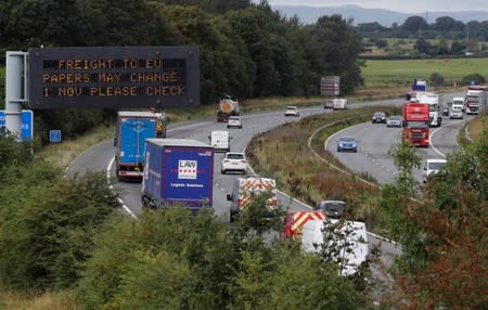 Vehicles pass beneath a sign warning of possible changes to freight procedures following Brexit on the M56 motorway near Chester, Britain