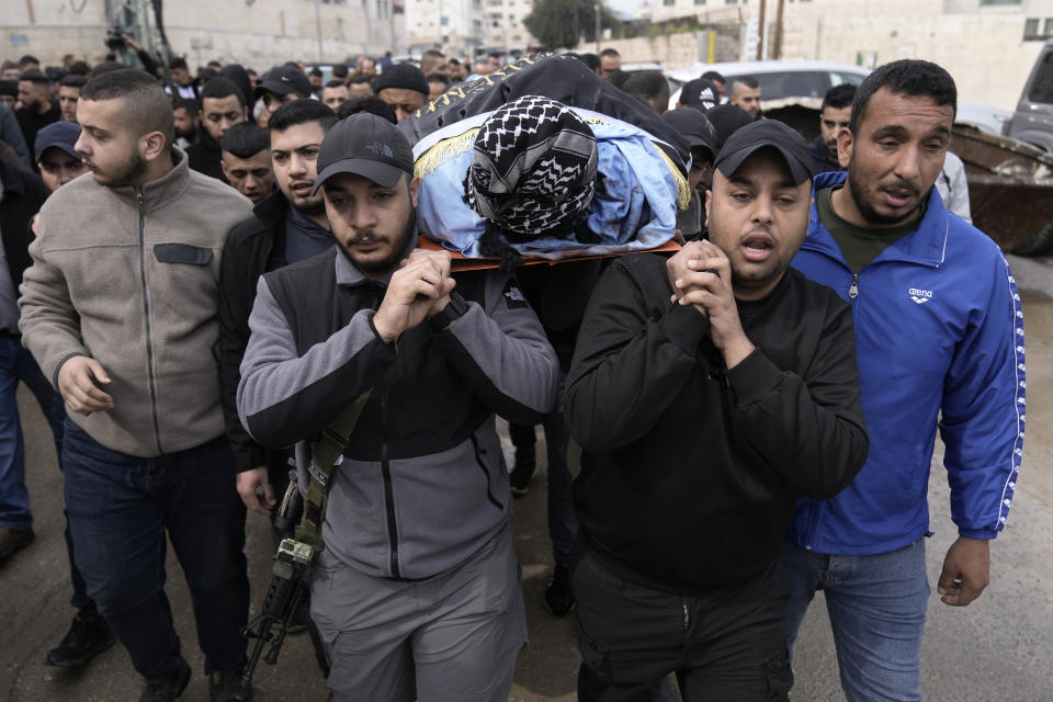 Gunmen carry the body of Yasser Hanoun, draped in the flag of the Islamic Jihad militant group, during his funeral alongside Said Jaradat on Friday, Feb. 23, 2024. The pair were killed in an Israeli drone strike on a car in the West Bank Jenin refugee camp a day earlier. The Israeli military alleged that Hanoun was previously involved in several shooting attacks targeting Israeli settlements and army posts. (AP Photo/Majdi Mohammed)