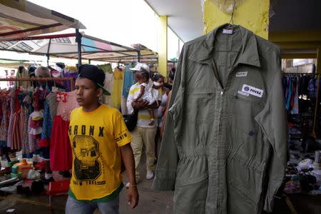 A boy walks past a PDVSA's overall for sale at a market in Maracaibo, Venezuela September 11, 2016. REUTERS/Jesus Contreras