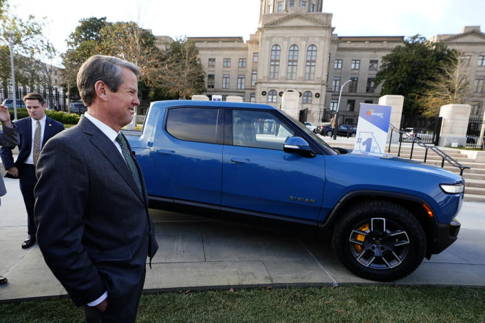 O governador Brian Kemp sorri ao lado de um caminhão elétrico da Rivian durante uma cerimônia para anunciar que a fabricante de caminhões elétricos planeja construir uma fábrica de baterias e montagem de US$ 5 bilhões a leste de Atlanta projetada para empregar 7.500 trabalhadores, quinta-feira, 16 de dezembro de 2021 , em Atlanta.  (Foto AP/John Bazemore)