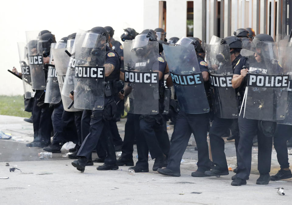 Police advance on protesters throwing rocks and water bottles during a demonstration next to the city of Miami Police Department, Saturday, May 30, 2020, downtown in Miami.Protests were held throughout the country over the death of George Floyd, a black man who died after being restrained by Minneapolis police officers on May 25. (AP Photo/Wilfredo Lee)