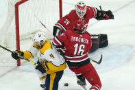 Carolina Hurricanes goaltender Alex Nedeljkovic (39) and center Vincent Trocheck (16) defend the goal against Nashville Predators defenseman Ryan Ellis (4) during the third period of an NHL hockey game in Raleigh, N.C., Saturday, April 17, 2021. (AP Photo/Gerry Broome)