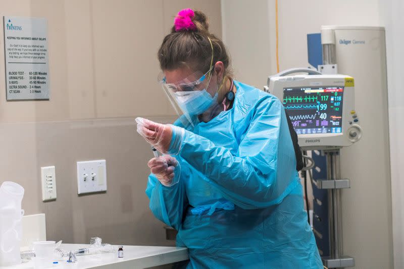 FILE PHOTO: A healthcare worker works on a coronavirus disease (COVID-19) test from a positive patient inside a COVID-19 unit at Trinitas Regional Medical Center in Elizabeth, New Jersey