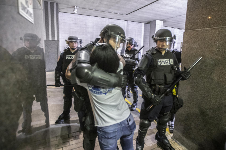 A protester hugs a police officer who kneeled after protesters attending a rally against the deaths of George Floyd and Breonna Taylor chanted "Kneel with us! Kneel with us!" in Lexington, Ky., on Sunday, May 31, 2020. (Ryan C. Hermens/Lexington Herald-Leader via AP)