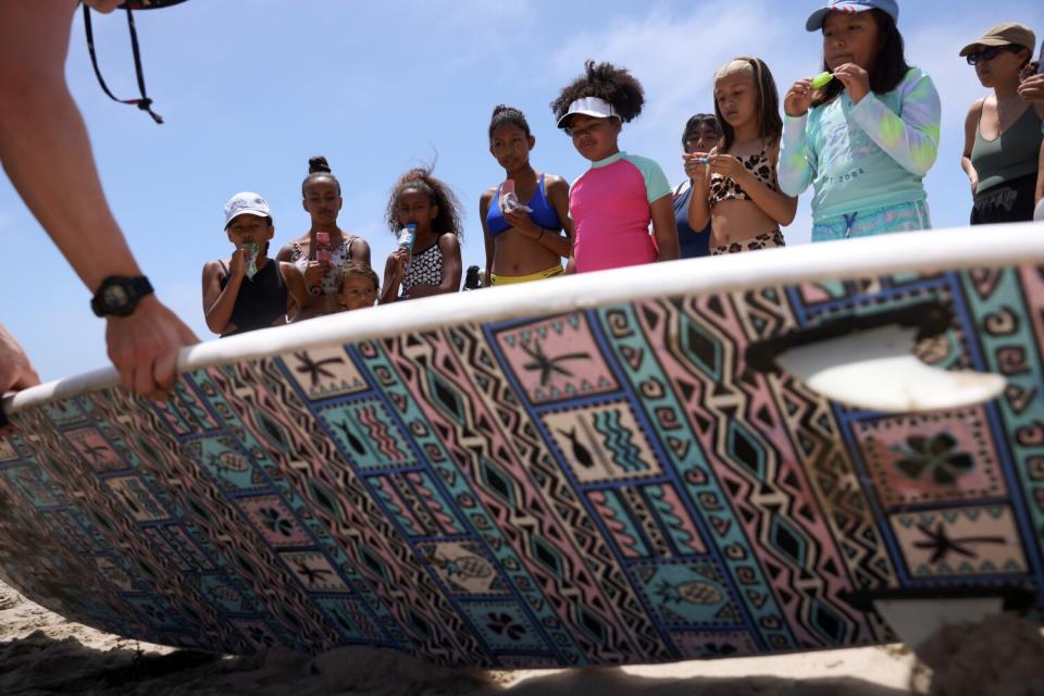 Participants in a Los Courage Camp event watch as an instructor gives tips on how to surf at First Point in Malibu.