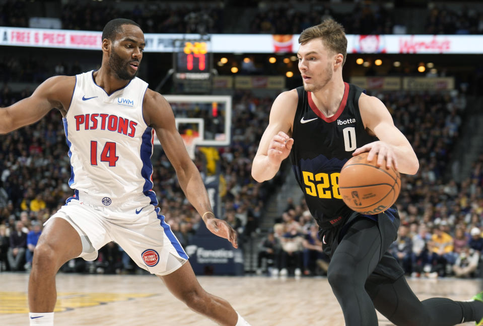 Denver Nuggets guard Christian Braun, right, drives to the basket as Detroit Pistons guard Alec Burks defends in the first half of an NBA basketball game Sunday, Jan. 7, 2024, in Denver. (AP Photo/David Zalubowski)