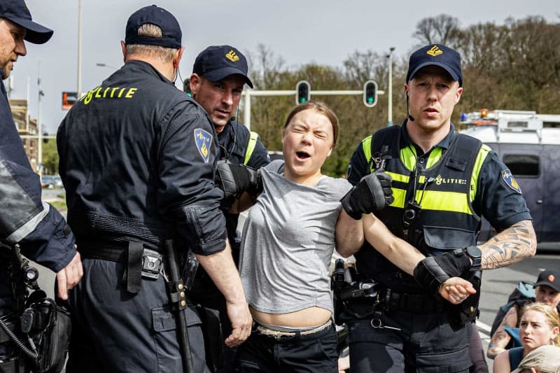 Swedish climate activist Greta Thunberg (C) is arrested during a road blockade on the A12 highway. Thunberg, who initially took part in an action by the group Extinction Rebellion (XR) with other demonstrators, was temporarily arrested twice by the police during road blockades in The Hague. Ramon Van Flymen/ANP/dpa