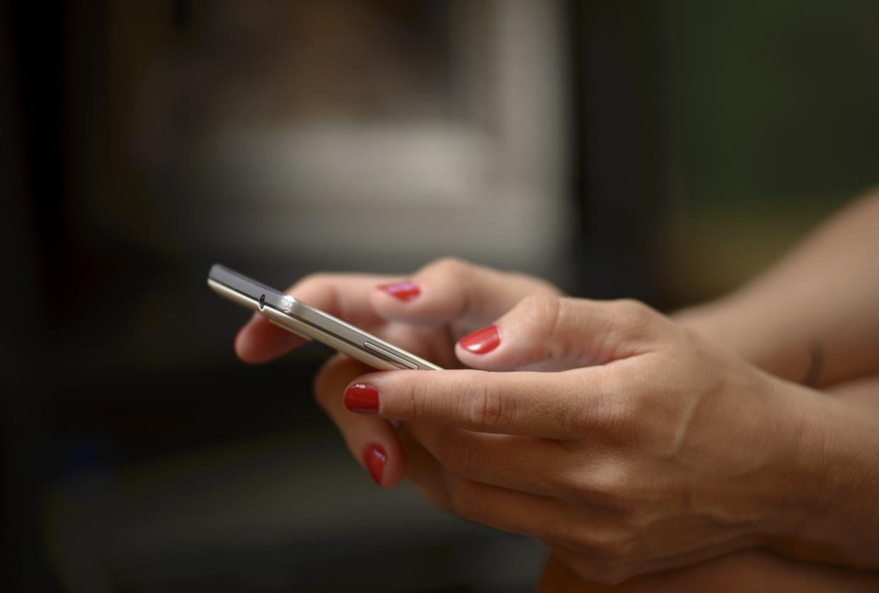 Cell phone in woman hands, sending text messages or surfing the web.