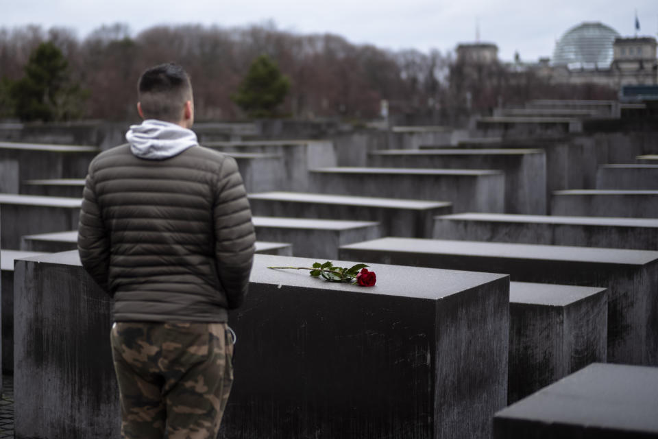 A young man stands in front of the Holocaust Memorial after he laid down a red rose on a slab of the memorial to commemorate the victims of the Nazis in Berlin, Sunday, Jan. 27, 2019. The International Holocaust Remembrance Day marks the liberation of the Auschwitz Nazi death camp on Jan. 27, 1945. (AP Photo/Markus Schreiber)