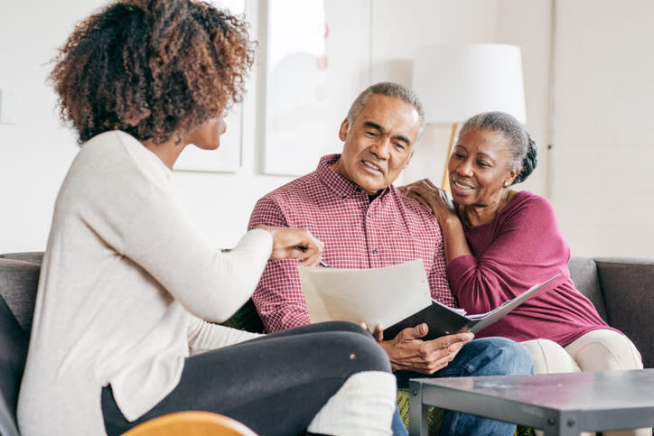 A senior couple discussing healthcare costs with a financial advisor.