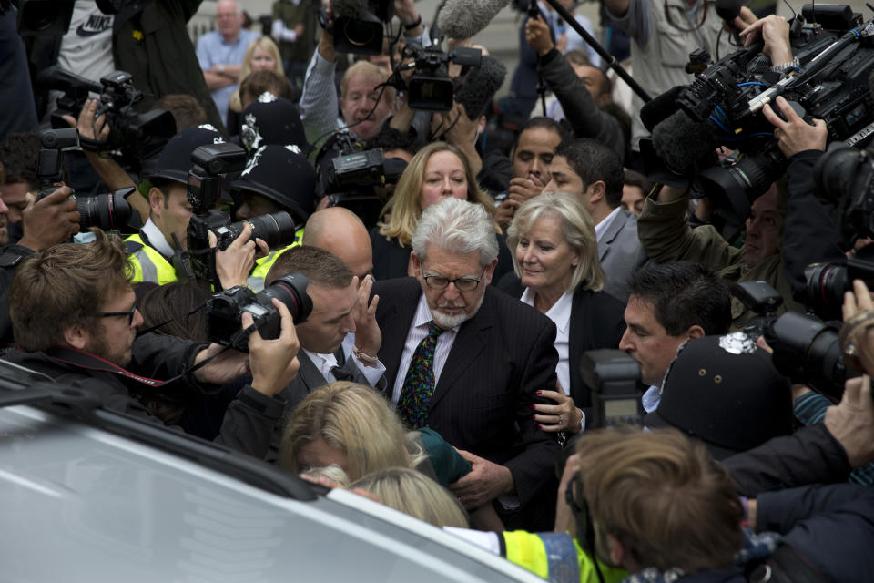 FILE - Veteran entertainer Rolf Harris, center, leaves Westminster Magistrate's Court in London, Monday, Sept. 23, 2013. Rolf Harris, the veteran entertainer whose decades-long career as a family favorite on British and Australian television was shattered when he was convicted of sexual assaults on young girls, has died. He was 93. (AP Photo/Matt Dunham, File)