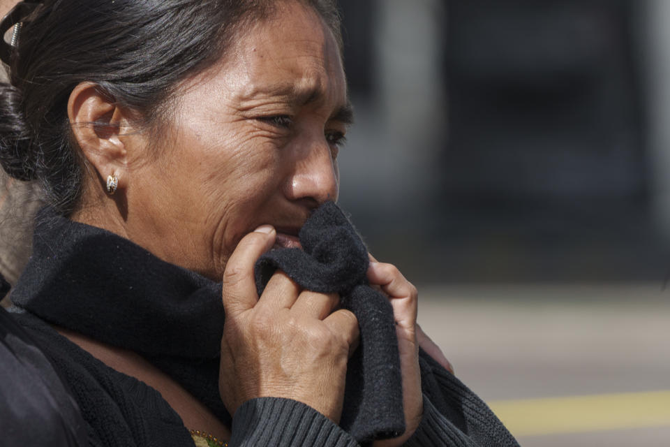 A woman cries after attending a meeting with a rescue worker, next to a sinkhole in Villa Nueva, Guatemala, Tuesday, Sept. 27, 2022. Search efforts were underway for a mother and daughter who disappeared when their vehicle was swallowed by a massive sinkhole. (AP Photo/Moises Castillo)