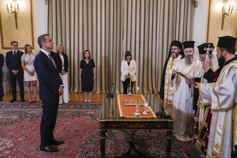 Greece's Prime Minister Kyriakos Mitsotakis, left, takes the oath during a swearing in ceremony at the Presidential palace, in Athens, Greece, Monday, June 26, 2023. Greece's center-right leader Kyriakos Mitsotakis received the mandate to form a new government Monday after easily winning a second term with a record-high margin over the leftwing opposition, in an election that also ushered new far-right parties into Parliament. (AP Photo/Thanassis Stavrakis)