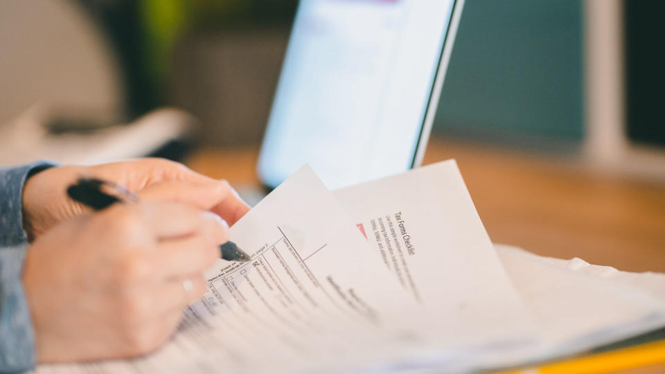 A woman scans through a W-9 forms as she does her taxes.