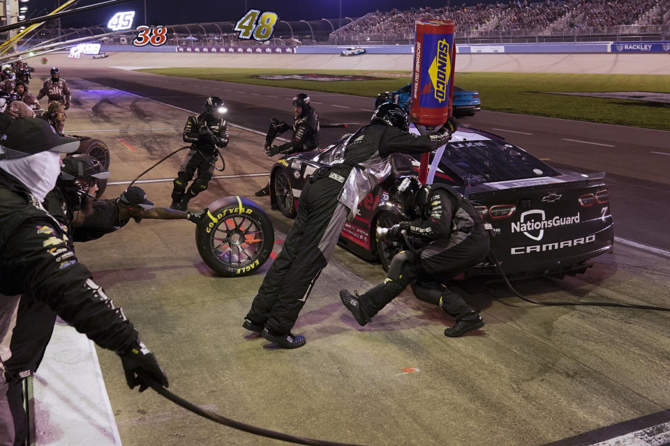 The pit crew works on Corey LaJoie's car during a NASCAR Cup Series auto race Sunday, June 25, 2023, in Lebanon, Tenn. (AP Photo/George Walker IV)