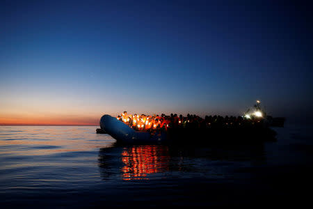 Migrants on a rubber dinghy await rescue by the Malta-based NGO Migrant Offshore Aid Station (MOAS) at dawn in the central Mediterranean in international waters off the coast of Sabratha in Libya, April 15, 2017. REUTERS/Darrin Zammit Lupi