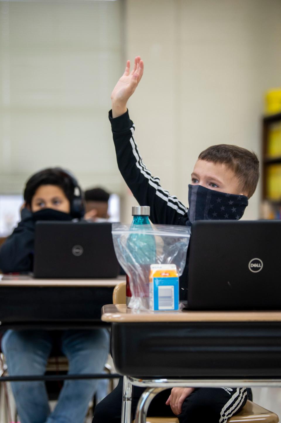 Fifth grader Chase Whitcroft raises his hand to ask a question on the first day back to in-person learning at DuPont Taylor Middle School on Friday, Feb. 26, 2021 in Nashville, Tenn. 