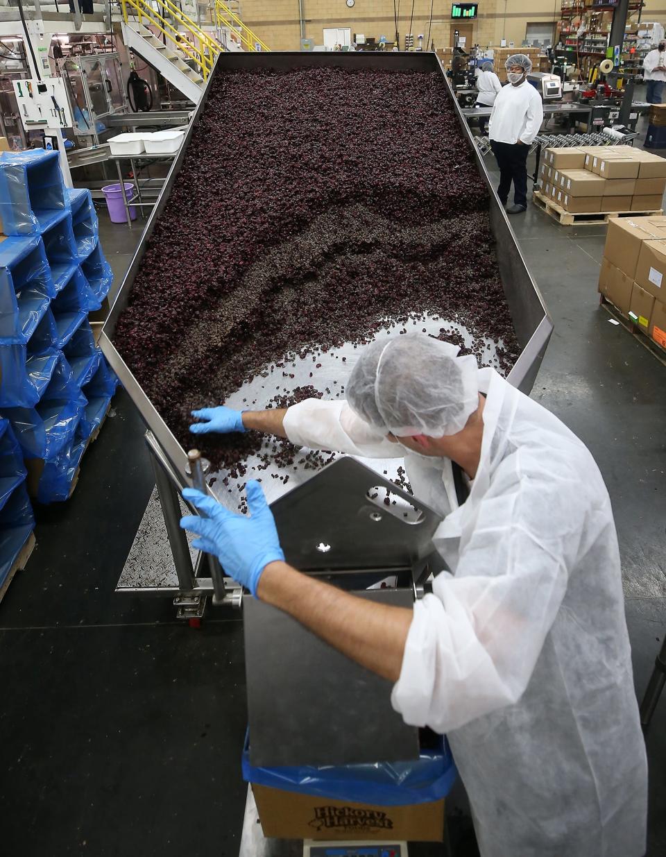 A worker scoops cranberry dark chocolate mix at Hickory Harvest, Tuesday, June 14, 2022, in Coventry Township, Ohio.