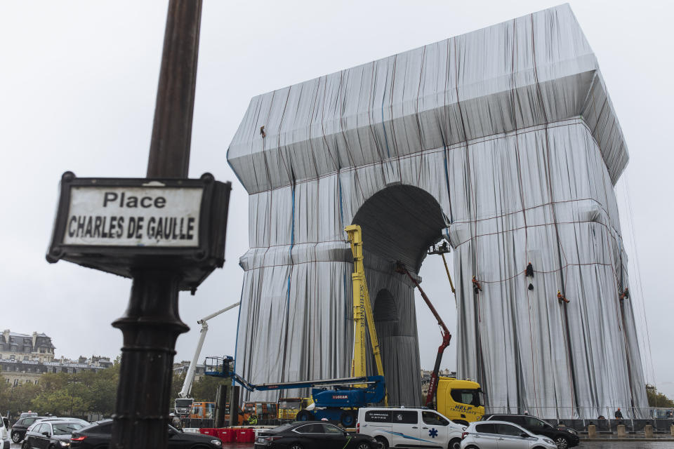 Workers wrap the Arc de Triomphe monument, Wednesday, Sept. 15, 2021 in Paris. The "L'Arc de Triomphe, Wrapped" project by late artist Christo and Jeanne-Claude will be on view from, Sept. 18 to Oct. 3. The famed Paris monument will be wrapped in 25,000 square meters of fabric in silvery blue, and with 3,000 meters of red rope. (AP Photo/Lewis Joly)