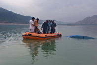 In this photo provided by Khyber Pakhtunkhwa's provincial rescue department 'Rescue 1122', rescue workers search bodies following a boat caspisdwe in Tanda lake, in Kohat, in the northwest Pakistan, Sunday, Jan. 29, 2023. Some students who were on a picnic drowned after their boat capsized in a lake in Pakistan's northwest on Sunday, police said. (Rescue 1122 via AP)