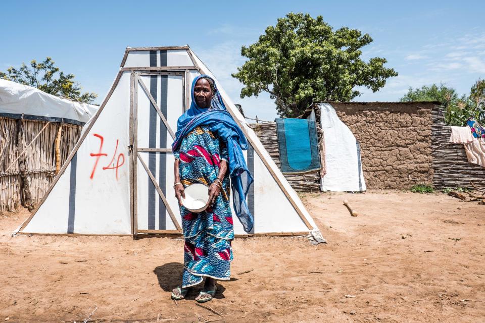 A displaced woman stands outside her tent in Sabon Gari, Nigeria. There are some 3,000 local residents and around 7,000 internally displaced people.