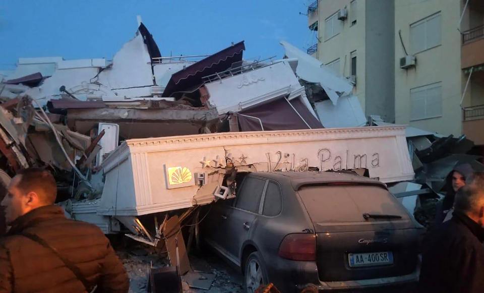 People stand next to a damaged hotel after an earthquake, in Durres, western Albania, Tuesday, Nov. 26, 2019. A magnitude-6.4 earthquake has shaken Albania. The United States Geological Survey said the earthquake was centered 30 kilometers (18.6 miles) northwest of the capital Tirana. It was at a depth of 10 kilometers (6.2 miles). (Photo: AP)  