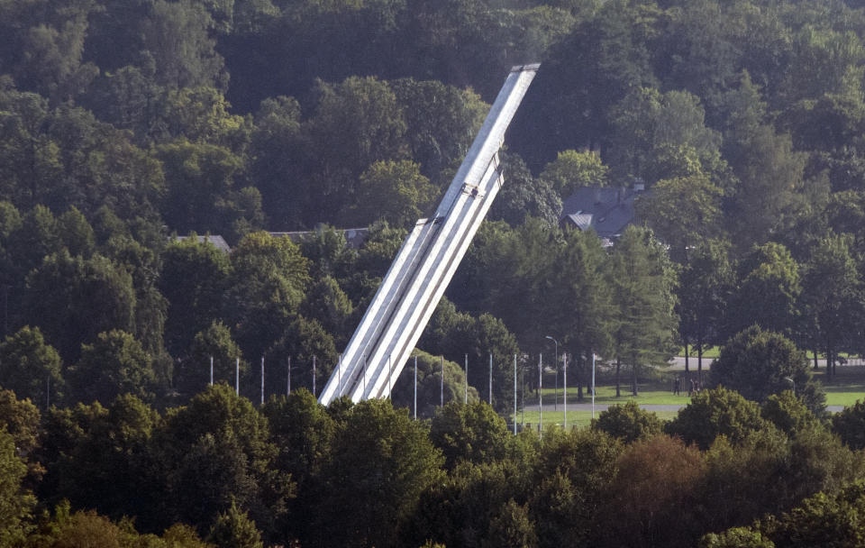 The Monument to the Liberators of Soviet Latvia and Riga from the German Fascist Invaders falls during demolition in Riga, Latvia, Thursday, Aug. 25, 2022. A nearly 80-meter (260-foot) concrete obelisk with Soviet stars at the top that was the center piece of a monument commemorating the Red Army’s victory over Nazi Germany, has been demolished Thursday in the Latvian capital. (Kaspars Krafts/F64 via AP)