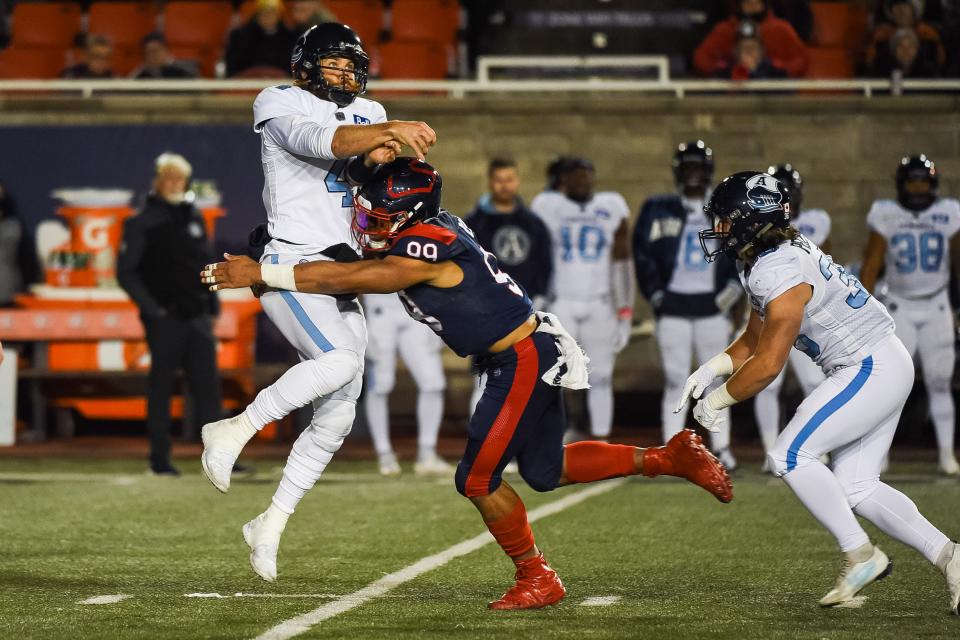 Montreal Alouettes defensive linesman Jamal Davis II (99) tackles Toronto Argonauts quarterback McLeod Bethel-Thompson in the third quarter during a CFL game, Oct. 22, 2021, at Molson Stadium, in Montreal.