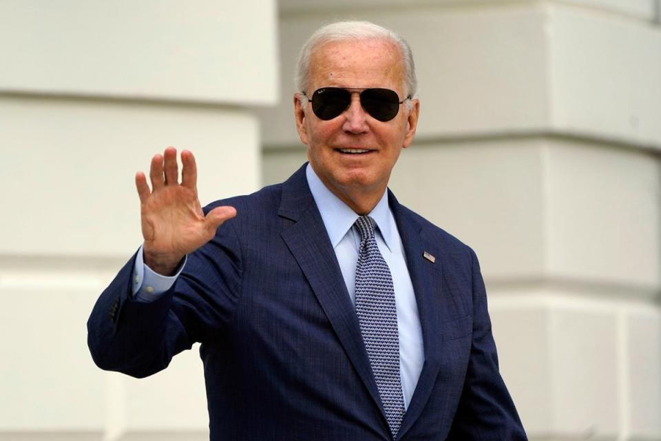 President Joe Biden waves to members of the media as he walks towards Marine One on the South Lawn of the White House on 11 August (Associated Press)