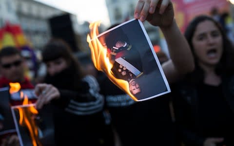 People set on fire photographs of Spain's King Felipe during the 87th Spanish Republic anniversary, paying tribute to people killed in the Spanish Civil War - Credit: Francisco Seco/ AP