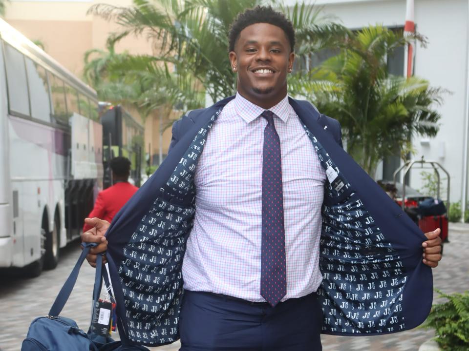 A Jackson State player shows off the lining of his new suit jacket.