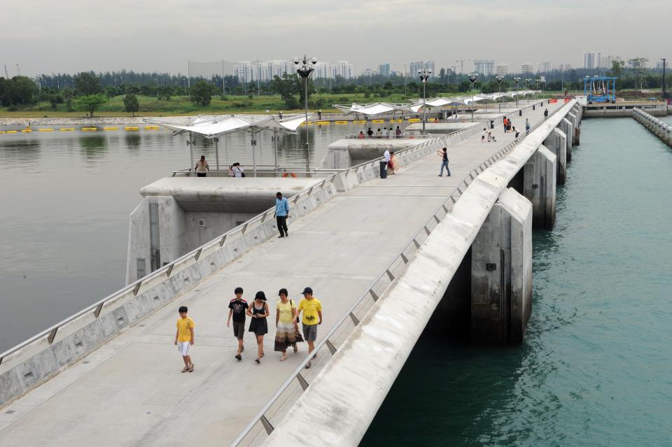 Visitors walk along the Marina Barrage water catchment area in Singapore on March 19, 2009.  Photographer: Roslan Rahman/AFP/Getty Images