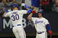 Texas Rangers' Nathaniel Lowe (30) celebrates with Mitch Garver after hitting a home run against the Houston Astros during the fifth inning in Game 5 of the baseball American League Championship Series Friday, Oct. 20, 2023, in Arlington, Texas. (AP Photo/Julio Cortez)