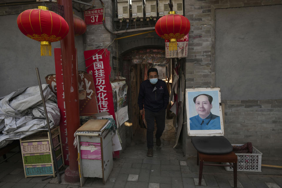 A man walks out from a Hutong near a portrait of late Chinese leader Mao Zedong in Beijing, China, Thursday, April 11, 2024. (AP Photo/Tatan Syuflana)