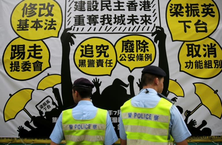 Police pictured in front of a banner during a pro-democracy rally in Hong Kong on July 1, 2015