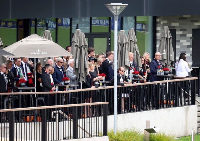 Guests watch from the Melbourne Cricket Ground clubhouse as the hearse carrying Shane Warne’s coffin does a lap of the pitch following Sunday's private funeral service 