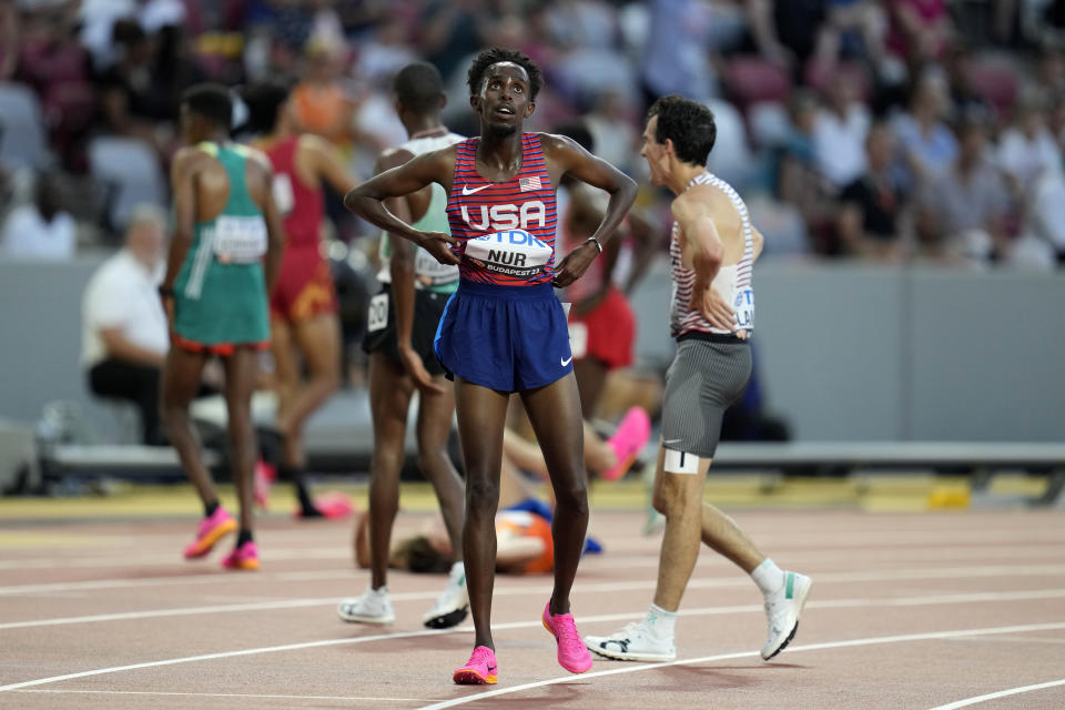 Abdihamid Nur, right, of the United States,, stands by after competing in the men's 5000-meters heats during the World Athletics Championships in Budapest, Hungary, Thursday, Aug. 24, 2023. (AP Photo/Ashley Landis)