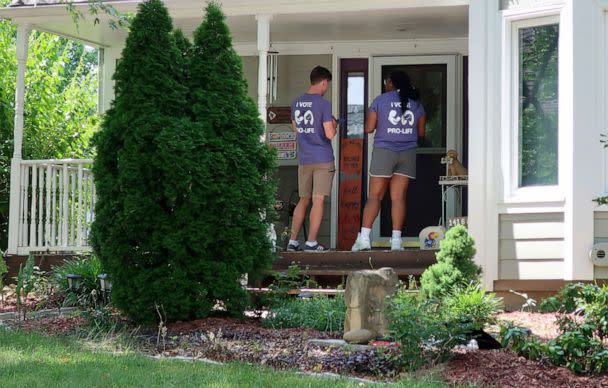 PHOTO: Ben Kennedy, left, and Alyssa Winters go door-to-door to speak with prospective voters about a proposed amendment to the Kansas constitution that would allow legislators to further restrict or ban abortion, July 8, 2022, in Olathe, Kan. (John Hanna/AP)