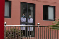 Medical workers look out from a healthcare center at the apartment houses compound built by the Chinese government in Yuexi county, southwest China's Sichuan province on Sept. 11, 2020. China's ruling Communist Party says its initiatives have helped to lift millions of people out of poverty. But they can require drastic changes, sometimes uprooting whole communities. They fuel complaints the party is trying to erase cultures as it prods minorities to embrace the language and lifestyle of the Han who make up more than 90% of China’s population. (AP Photo/Andy Wong)