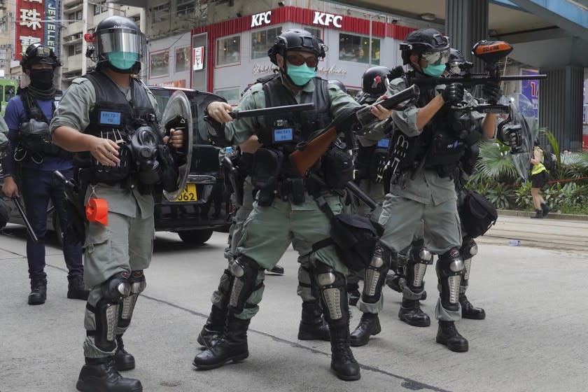 Hong Kong riot police fire tear gas as hundreds of protesters march along a downtown street during a pro-democracy protest against Beijing's national security legislation in Hong Kong, Sunday, May 24, 2020. Hong Kong's pro-democracy camp has sharply criticised China's move to enact national security legislation in the semi-autonomous territory. They say it goes against the "one country, two systems" framework that promises the city freedoms not found on the mainland. (AP Photo/Vincent Yu)