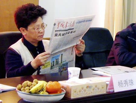 Yang Xiuzhu reads a newspaper during a meeting in Wenzhou, Zhejiang province, December 29, 2001. REUTERS/Stringer/Files