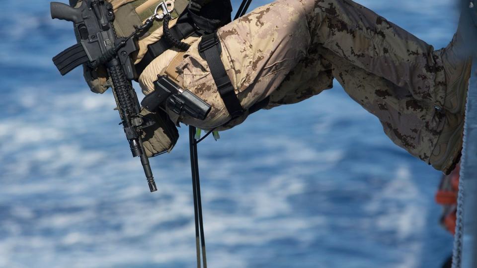 A Canadian service member rappels down the side of a ship during an exercise with the naval forces of Canada, Japan, Australia and the United States. (LSIS Bradley Darvill/Royal Australian Navy)