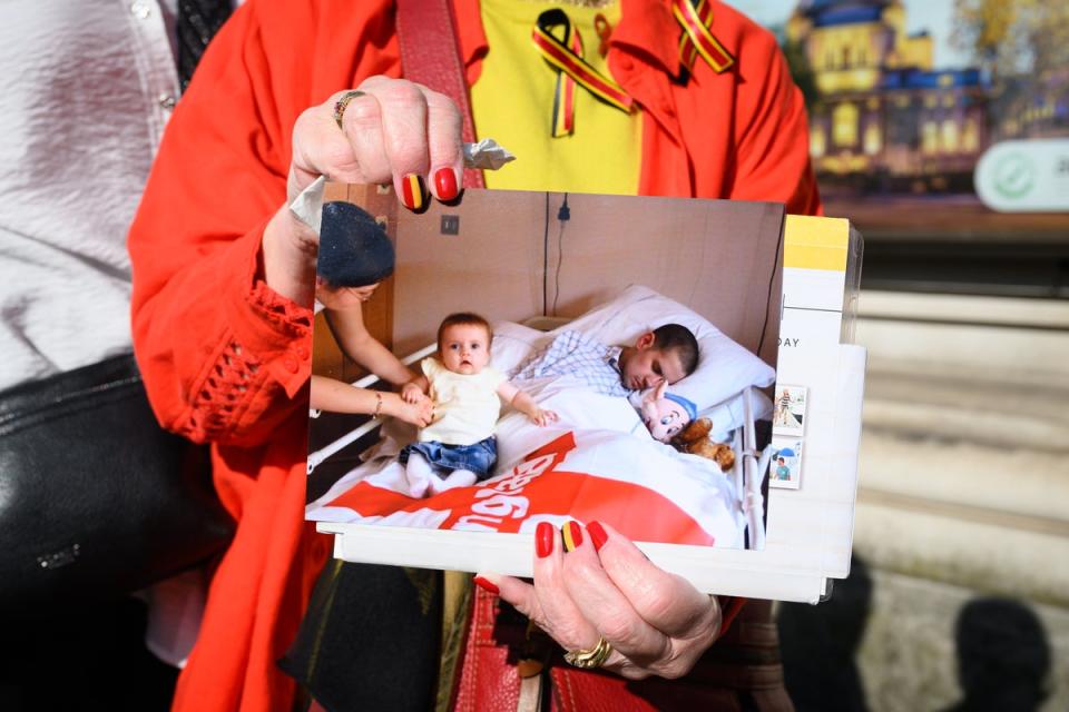 A woman holds a photograph of Marc Payton, who died in 2003 after being mistakenly infected with HIV and hepatitis C while in a children's hospital (Getty)