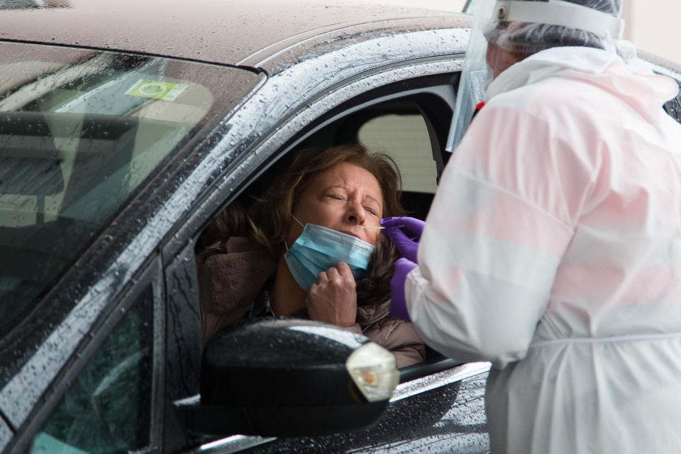 A health worker wearing a personal protective equipment suit takes a nasal swab sample from a teacher before the return of students in Slovenia. (PA)