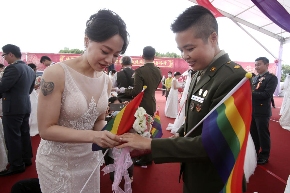 Lesbian couple Yumi Meng, left, puts a ring on Yi Wang' s finger during a military mass weddings ceremony in Taoyuan city, northern Taiwan, Friday, Oct. 30, 2020. Two lesbian couples tied the knot in a mass ceremony held by Taiwan's military on Friday in a historic step for the island. Taiwan is the only place in Asia to have legalized gay marriage, passing legislation in this regard in May 2019. (AP Photo/Chiang Ying-ying)